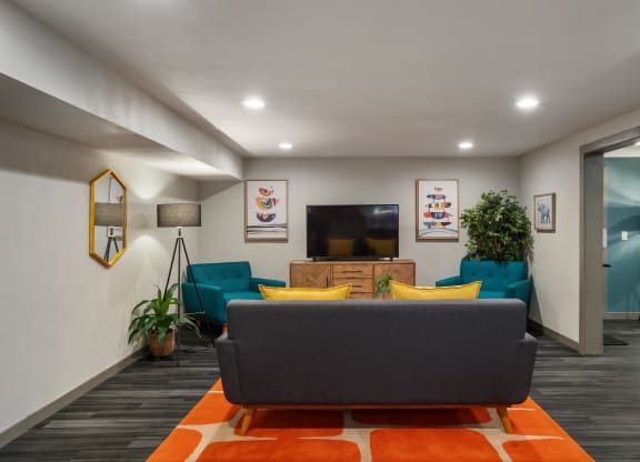 a living room with blue couches and yellow and orange pillows at Cedarwood, Wenatchee