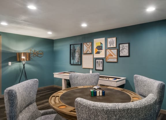a game room with blue walls and a round table with three chairs at Cedarwood, Wenatchee, WA 98801