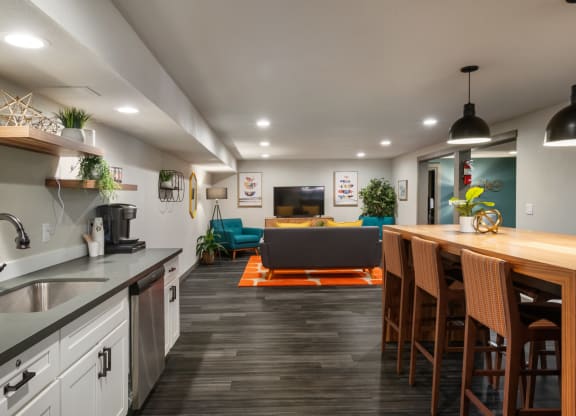 a kitchen with white cabinets and a wooden counter top next to a living room with a couch at Cedarwood, Wenatchee, WA 98801