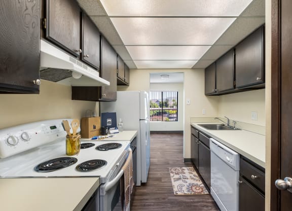 kitchen with dark wood cabinets and open to dining with window at Castlerock, Washington