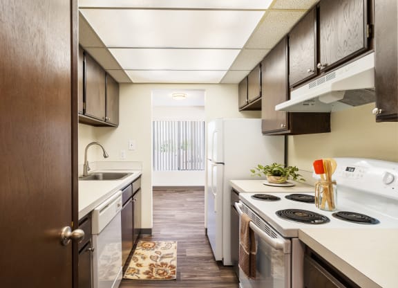 kitchen with dark wood cabinets and open to dining with window at Castlerock, Washington, 98801