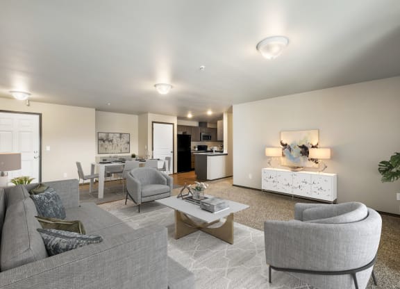 a living room with grey couches and chairs and a white coffee table in front of a  at Altitude, East Wenatchee