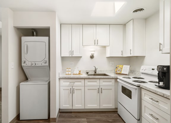 a kitchen with white cabinets and a white washer and dryer at Park View Apartments, Wenatchee, WA 98801