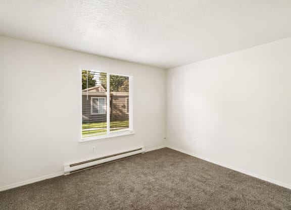 an empty room with carpet and a window  at Park View Apartments, Washington, 98801