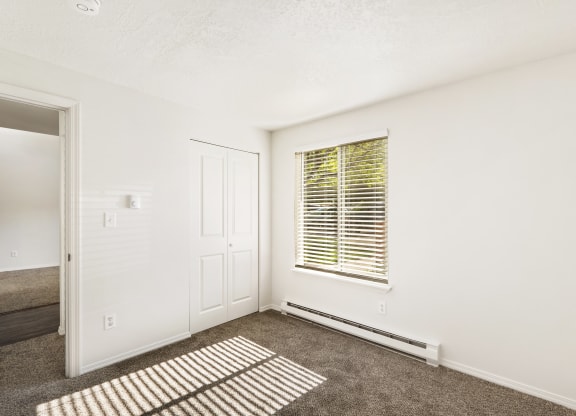 the living room of an apartment with carpet and a window  at Park View Apartments, Wenatchee, Washington