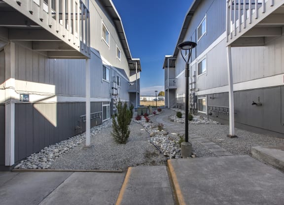 Exterior view of manicured rock path between buildings at The Lakes Apartments, Moses Lake, WA.