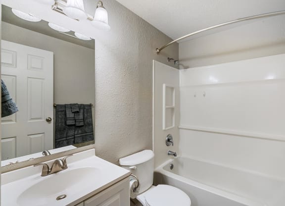 Bathroom with white counters, a mirror, sink, toilet, shower, and bath tub from left to right.at Capitol Crossing, Olympia, WA 98501