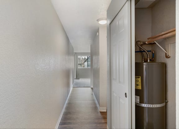 a hallway with a white door and a stainless steel water tank
