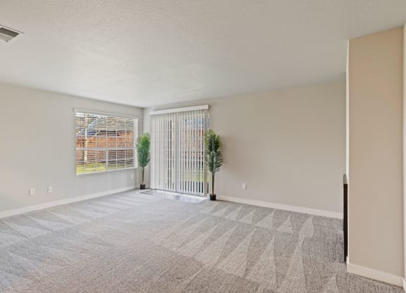 an empty living room with white walls and a window