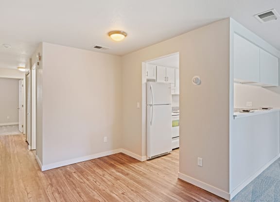 Wood floor hallway with laundry and linen closet leading to carpeted bedroom with kitchen on right side.at Capitol Crossing, Olympia, WA 98501