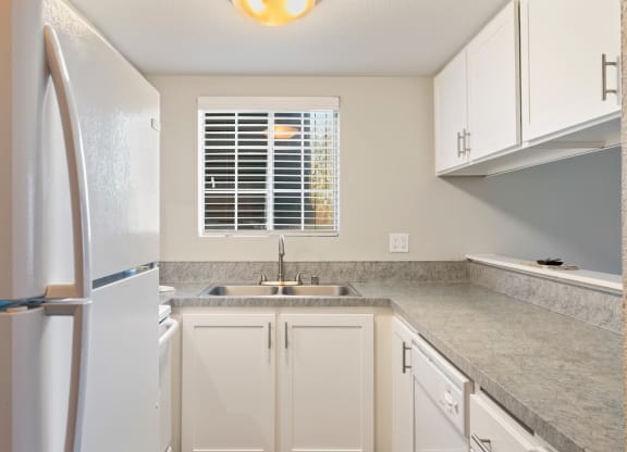 a kitchen with white cabinets and a sink and a refrigerator