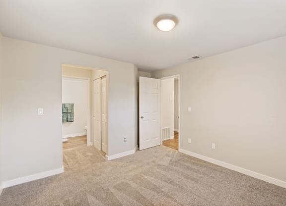 Bedroom with a hallway lined with closets to bathroom on left and door leading to rest of home on right.at Capitol Crossing, Olympia, 98501