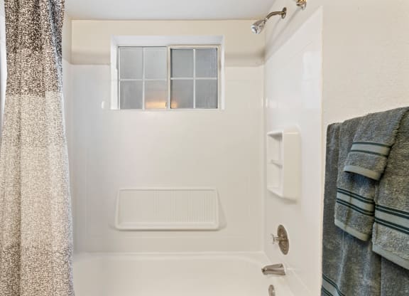 a small bathroom with a shower and a window