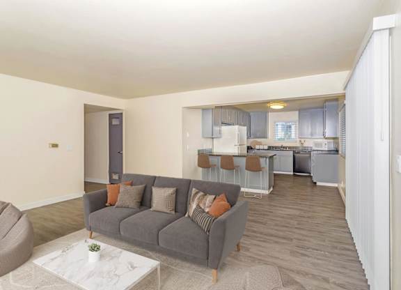 Open-concept living room with couch and coffee table in student apartments at Gateway Chico