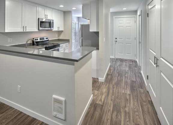 a renovated kitchen with white cabinets and stainless steel appliances at Edmonds Gateway, Edmonds, WA 98026