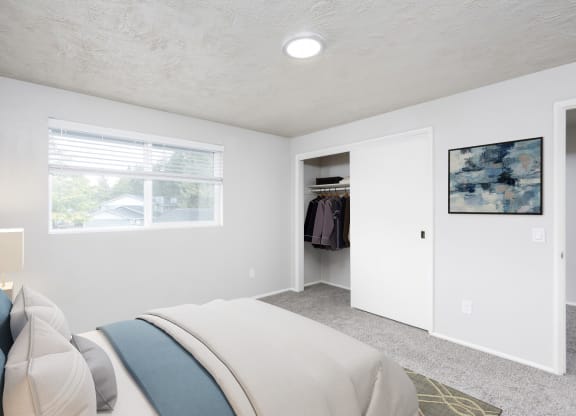 a bedroom with a bed and a closet and a window