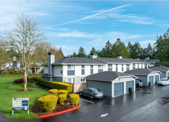 a view of the exterior of a building with cars parked in a parking lot