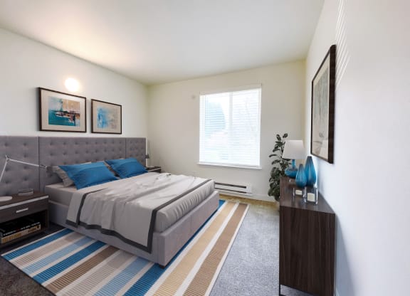 a bedroom with a bed, a dresser, 2 side tables and a large sunny window.at The Trail, Snohomish