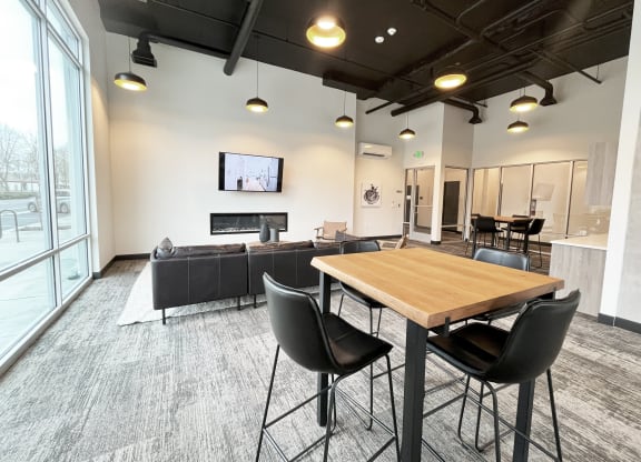 a communal area with a table and chairs and a living room with a tv at The Duo, Washington, 98466