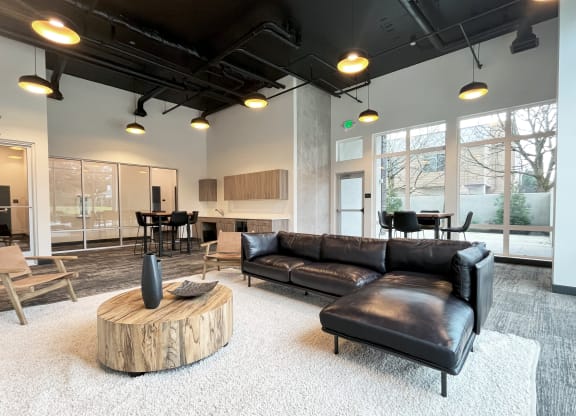 a living room with a leather couch and a coffee table at The Duo, University Place, WA 