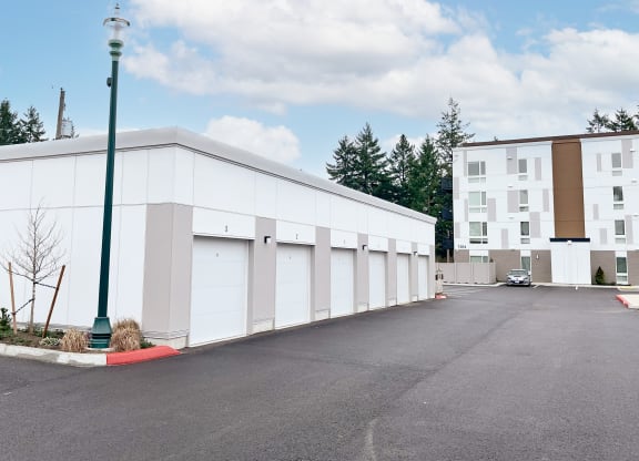 The Duo tenant garages with a parking lot in front of them at The Duo, University Place, 98466