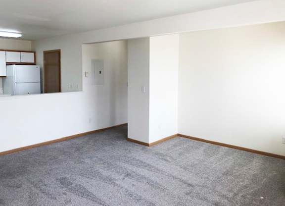 A room with a grey carpet and white walls.