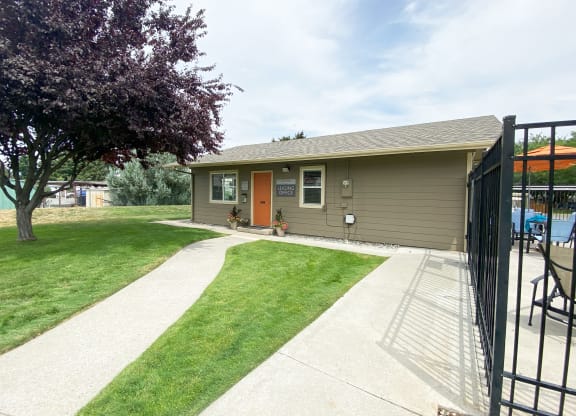 a home with a red door and a large tree in front of it at Park View Apartments, Washington