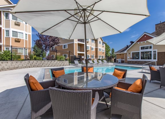 our apartments have a large pool and patio with chairs and umbrellas. Poolside lounge area