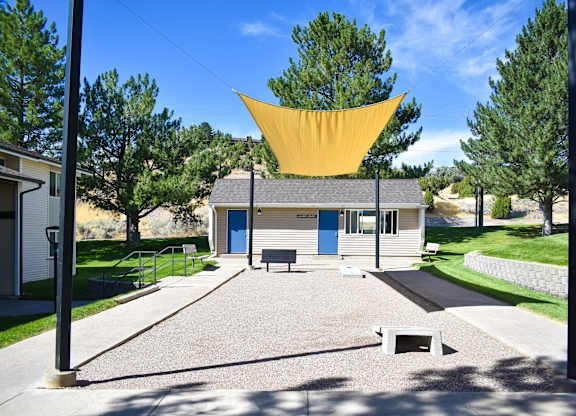 Covered game area at Kirkwood Meadows Apartments in Pocatello, ID. Green grass area with Corn Hole game.