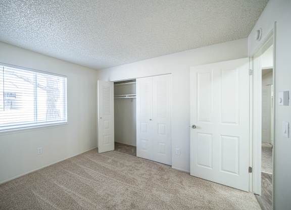 an empty bedroom with a closet and a window at Kirkwood in Pocatello, ID