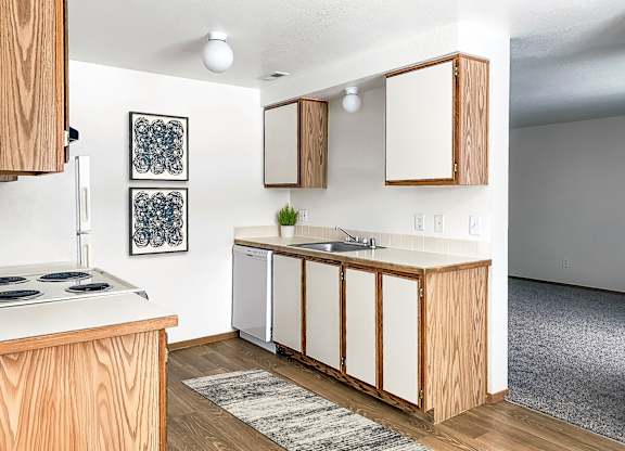 our apartments offer a kitchen with white appliances and wood cabinets at Shiloh Glen, Billings, MT 59102