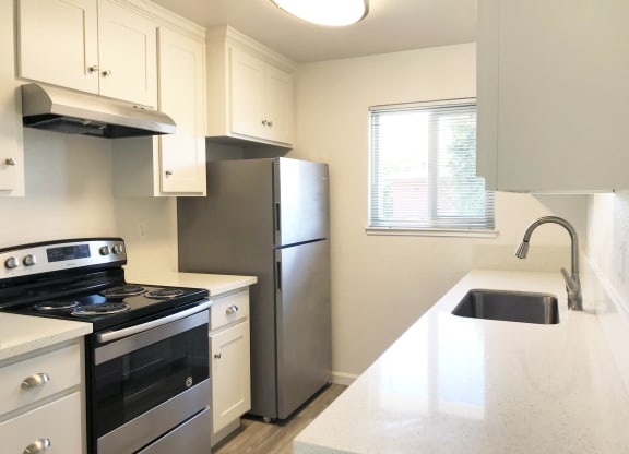 a kitchen with stainless steel appliances and a white counter top at Ella 1711 Apartments, Woodland, CA 95695
