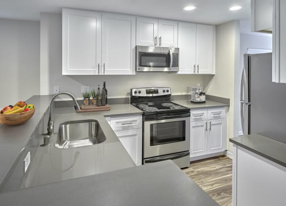 Updated kitchen with stainless steel appliances, white cabinets, and grey countertops.at Edmonds Gateway, Edmonds Washington