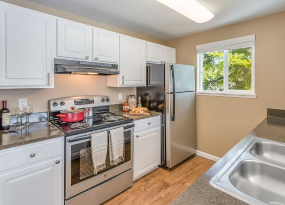 a kitchen with stainless steel appliances and white cabinets  at Springfield, Renton, 98055