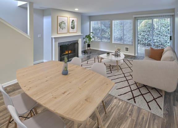 Living and Dining open layout with a fireplace, lots of windows and finished with a small dining set, coffee table and couch.at Edmonds Gateway, Edmonds, 98026