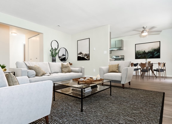 Living room with couch, two chairs, and coffee table.  Dining room visible in the back at University Glen, Washington