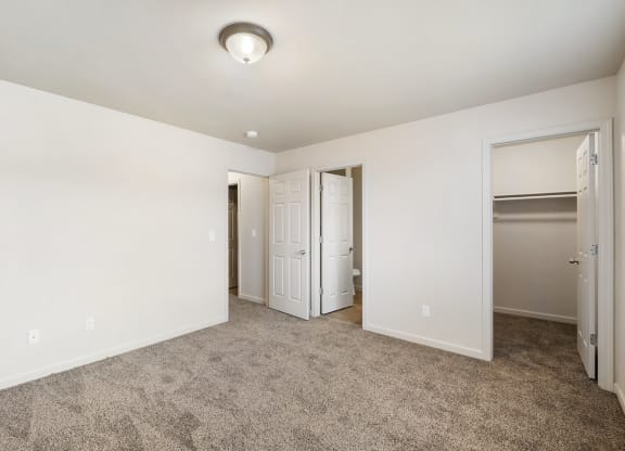 Clean, bright bedroom with taupe carpet, white walls and a large closet. at Pine Tree Park, Kennewick, 99337