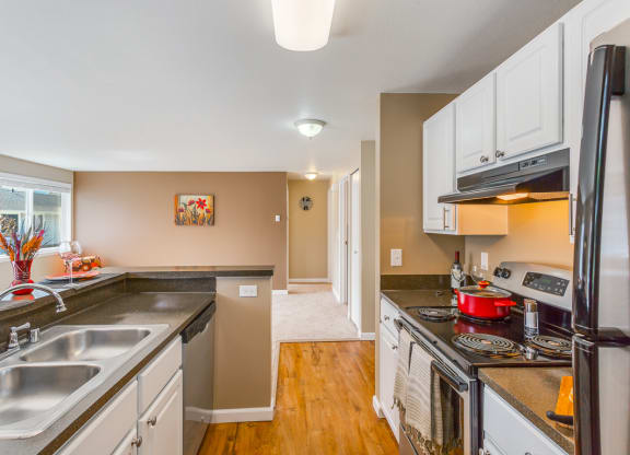 a kitchen with a stove and a sink and a refrigerator at Springfield, Washington, 98055 
