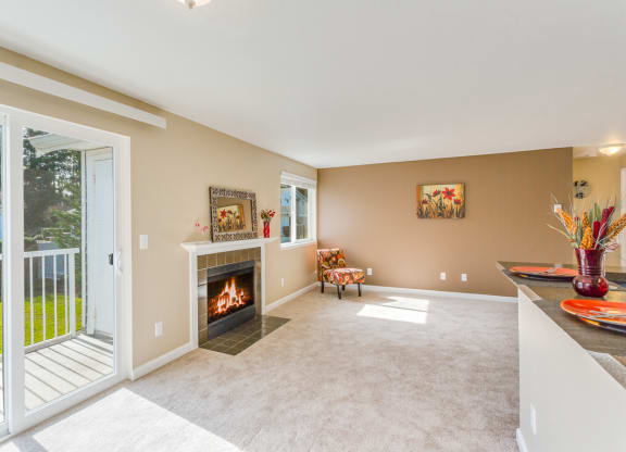 a living room with a fireplace and a balcony at Springfield, Renton, WA 98055