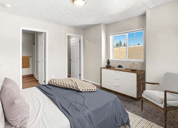 A bedroom with a bed, chair, and a window with a view of a field in Post Falls, ID Apartments.