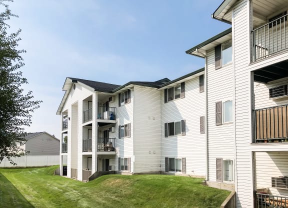 a view of apartments with balconies surrounded by green grass. at North Pointe, Post Falls, ID 83854