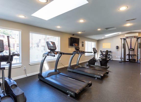 two treadmills and other exercise equipment in the gym of a home