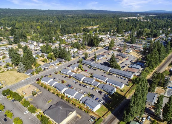 Exterior community ariel view, property is lined with trees, grass, and mountain tops in the background.at Quilceda Gardens, Washington, 98270