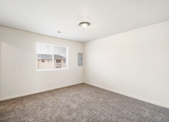 Clean, bright bedroom with taupe carpet, white walls and a large window in one wall. at Pine Tree Park, Washington, 99337