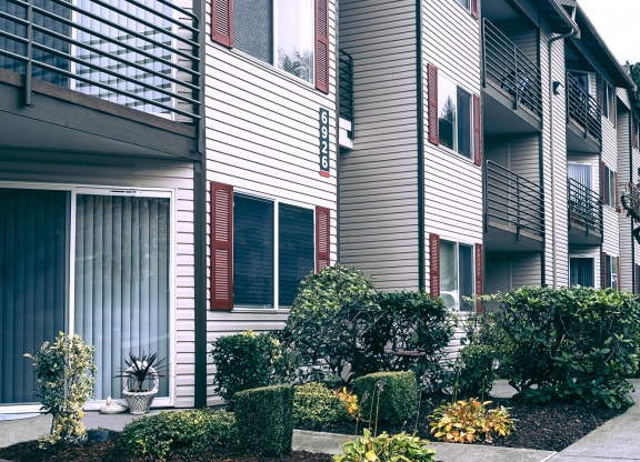 Sitka Heights exterior, paved pathway surrounded by landscaping leading to apartments with patios and balconies.at Sitka Heights, Fife, WA 98424