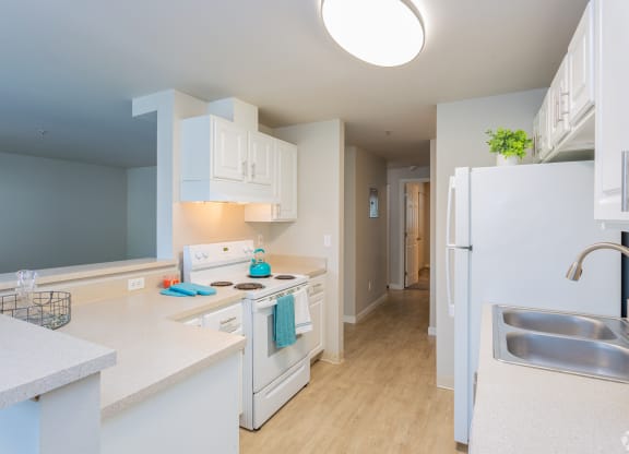 a kitchen with white cabinets and a stove and a refrigerator at Sitka Heights in Fife