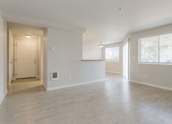 the living room and dining room of an empty home with a large window at Sitka Heights in Fife