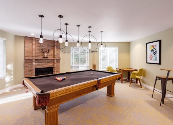 a living room with a pool table and a fireplace
