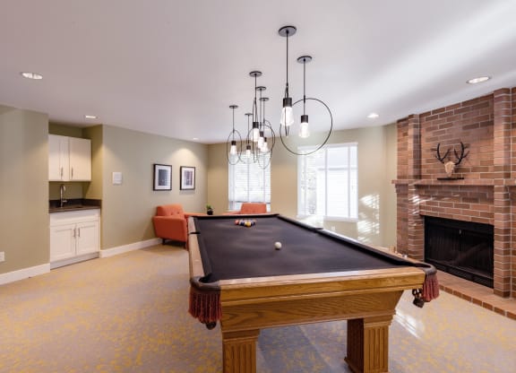 a game room with a pool table and a fireplace