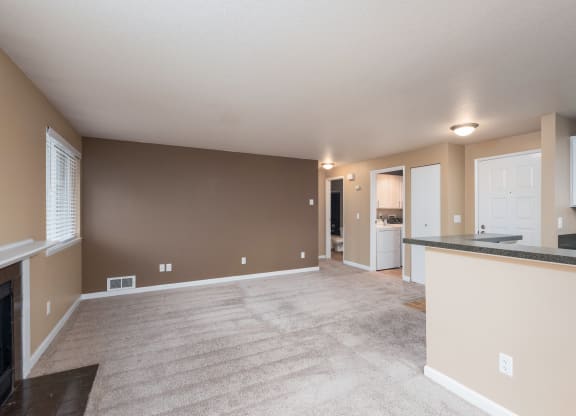 the living room and kitchen of an empty house